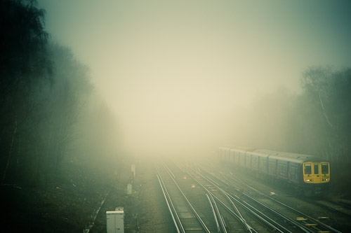 A Commuter Train from London passes through a Misty Wooded Area of Petts Wood in the South Eastern London Suburbs